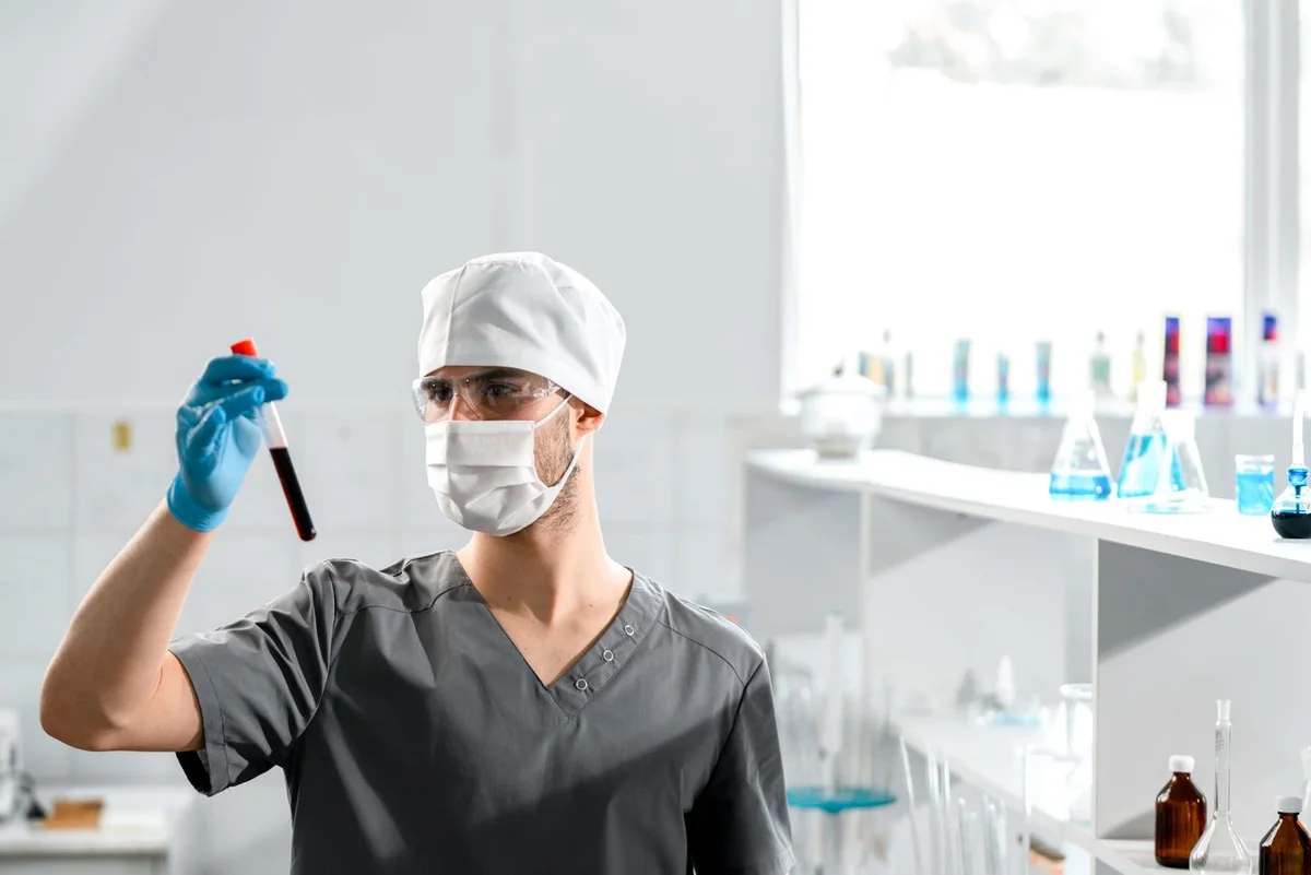 Profesional de laboratorio observando un tubo de muestra
